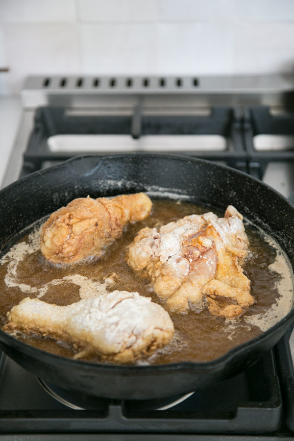 gluten-free fried chicken frying in a skillet on the stovetop 