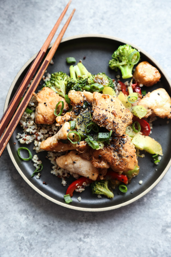 Sesame Chicken with Broccoli and Red Peppers on a black plate
