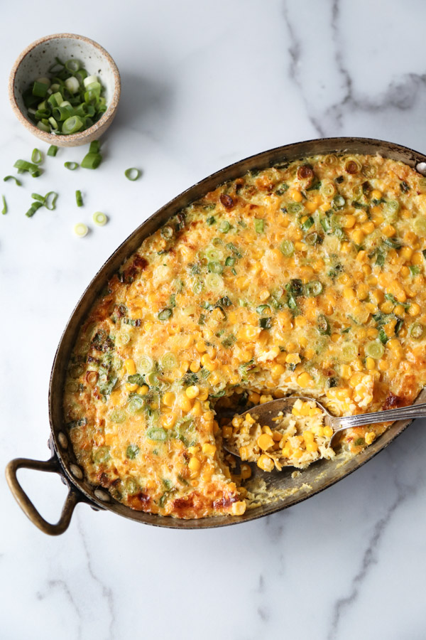 healthy corn pudding overhead in casserole pan with spoon