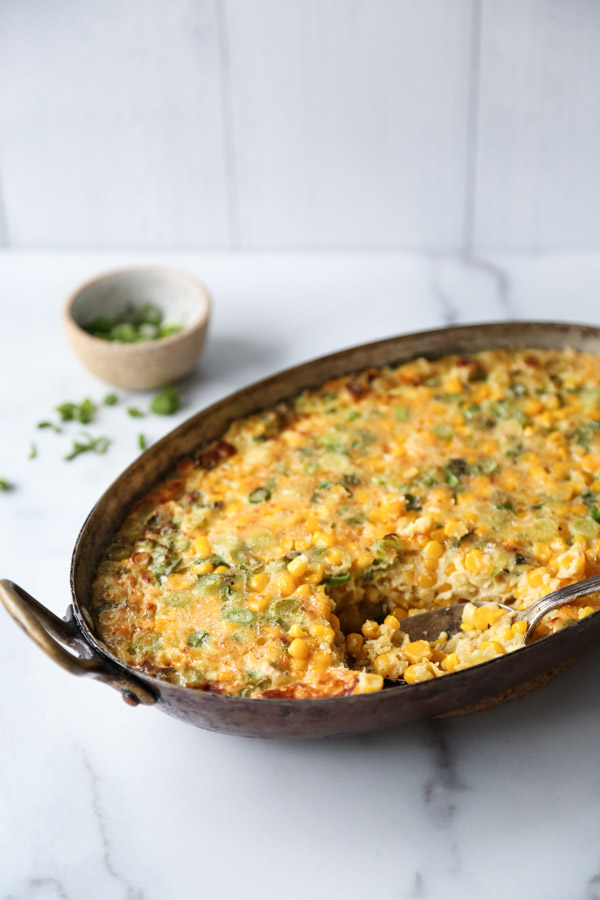 side view of baked healthy corn pudding casserole with spoon