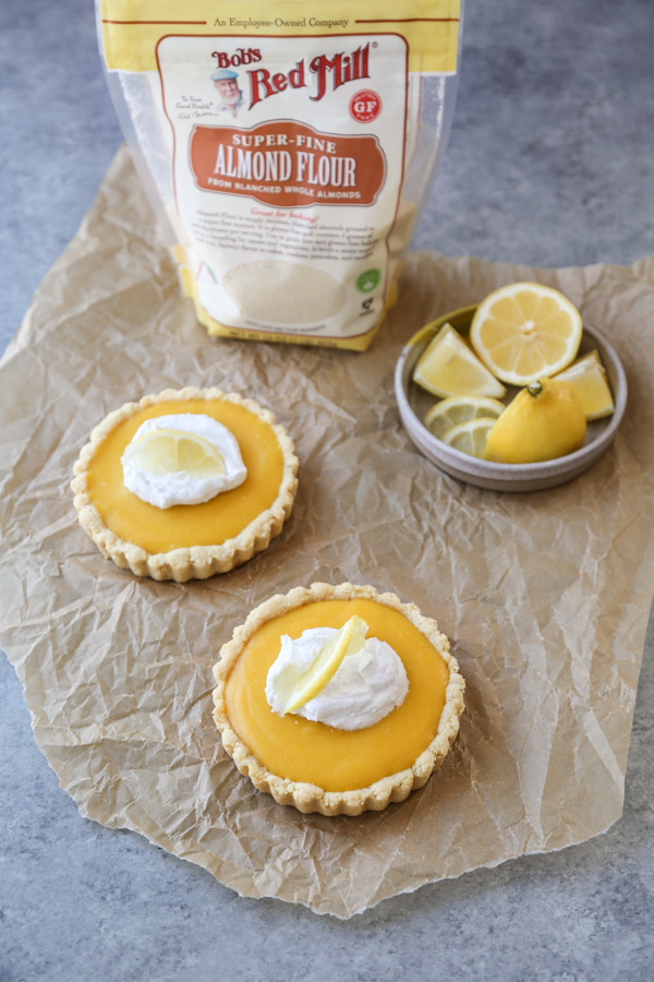 two mini gluten-free lemon curd tarts on parchment paper