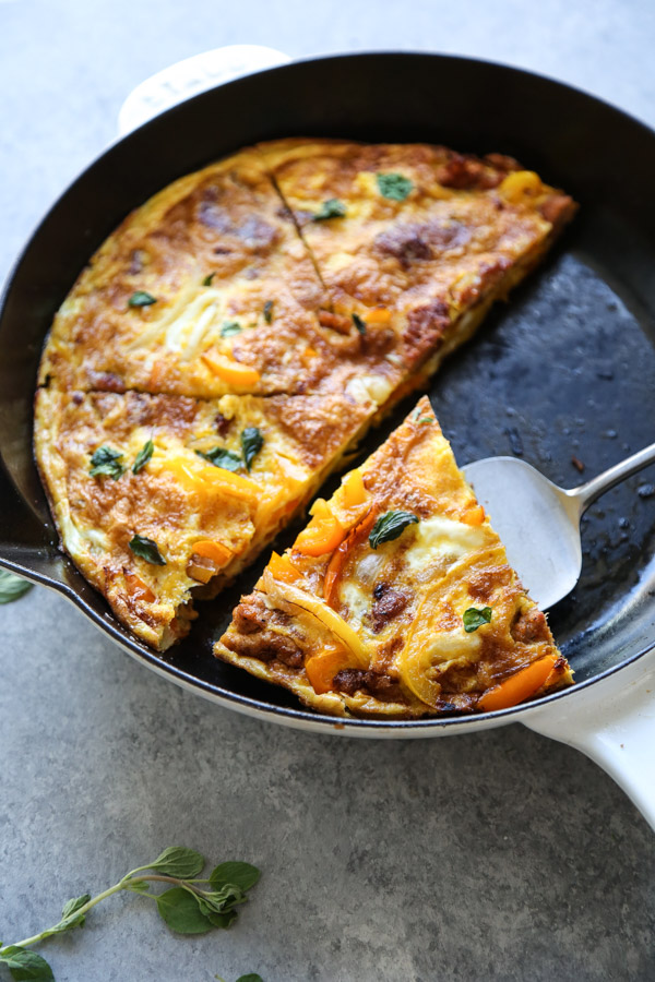 serving slice of Italian sausage frittata from the pan