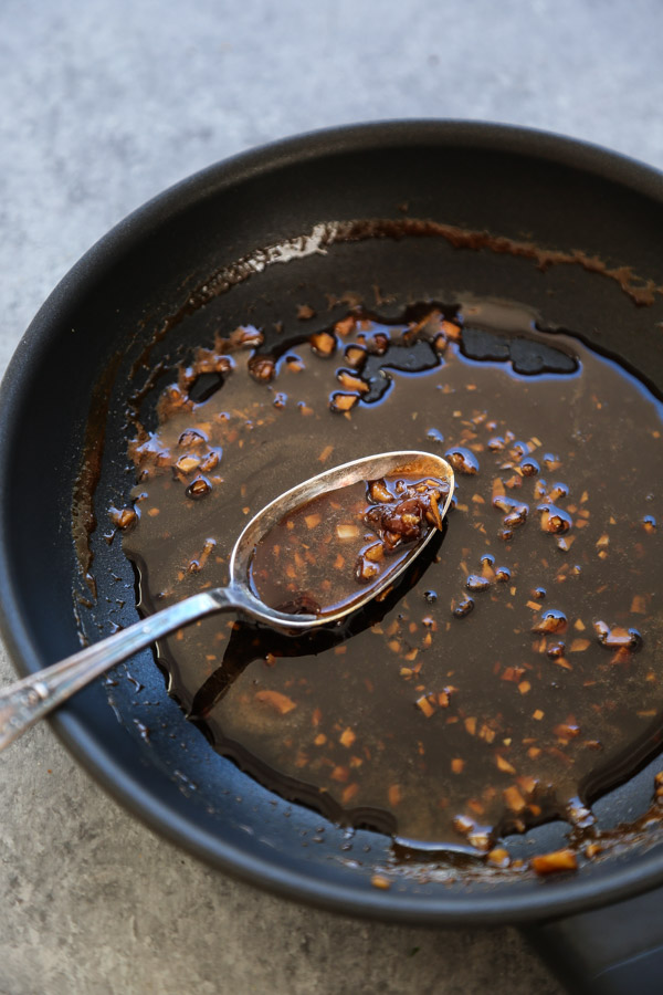 teriyaki marinade reduction in a saucepan with spoon