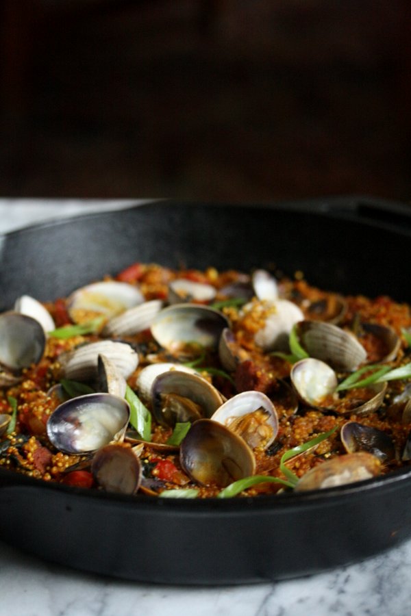 An easy quinoa paella with spicy chorizo sausage, seafood, peppers and winter greens. It's a great healthy spin on classic Spanish paella.