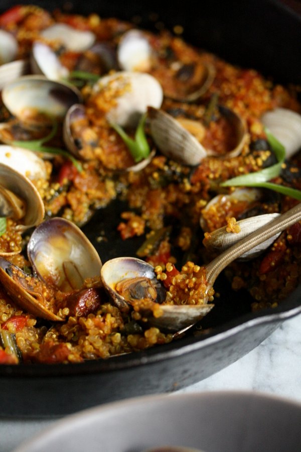 An easy quinoa paella with spicy chorizo sausage, seafood, peppers and winter greens. It's a great healthy spin on classic Spanish paella.