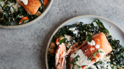 Seared Salmon on a plate with kale, chickpeas, quinoa and sauce