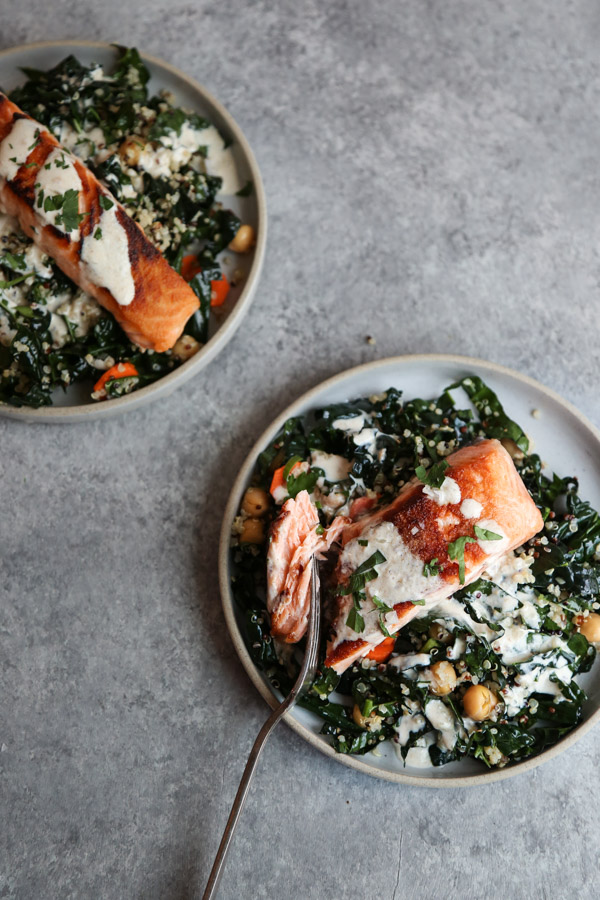 Seared Salmon on a plate with kale, chickpeas, quinoa and sauce