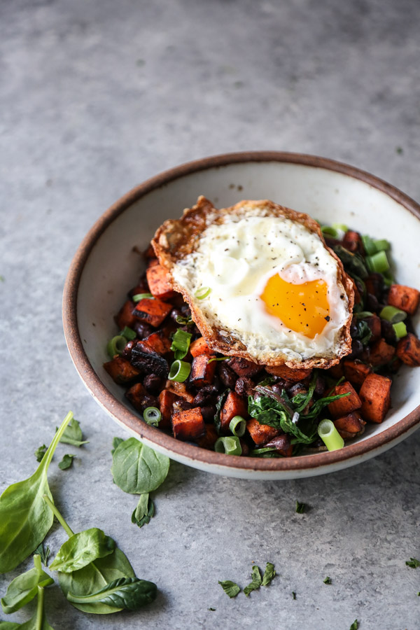 sweet potato black bean hash in a bowl with fried egg