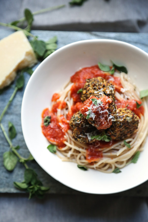 Gluten-free Vegetarian Meatballs  made from Lentils, Quinoa and Hemp Seeds overhead in a bowl with tomato sauce and pasta and basil on the side