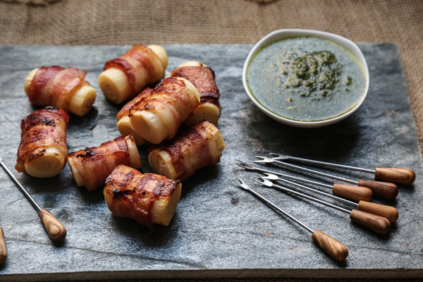 An Easy 3-Ingredient Hearts of Palm Appetizer Recipe. Wrapped with Bacon, crisped in the oven, and served alongside pesto. A Brazilian party favorite! | Feed Me Phoebe