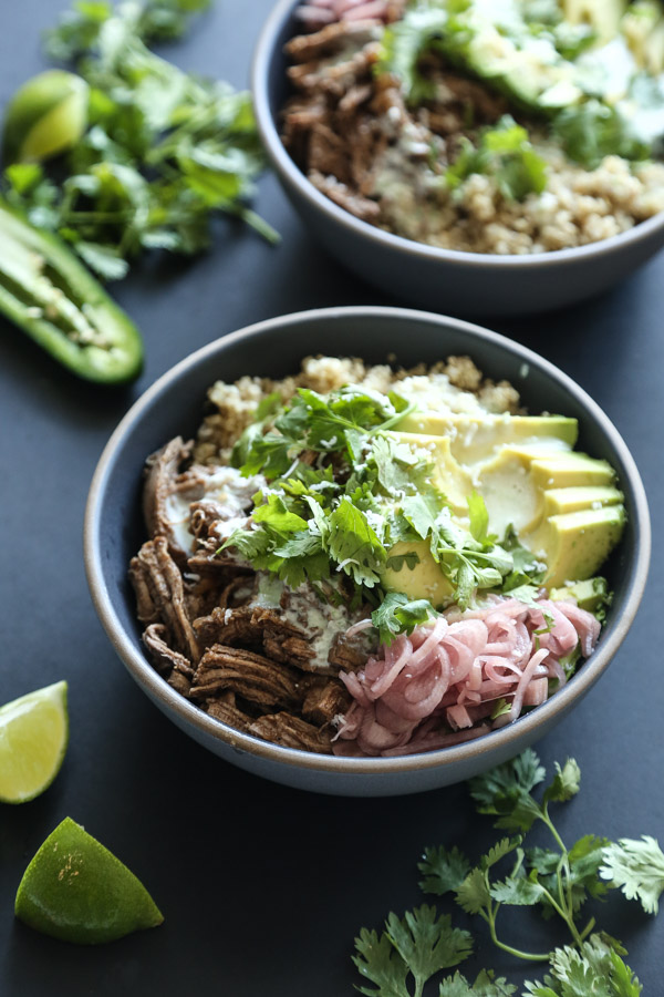 The quick pulled pork for this healthy burrito bowl recipe is a quick sweet and sour spin on Mexican carnitas. It's perfect with quinoa, avocado, pickled shallots and kefir jalapeno crema! | Feed Me Phoebe