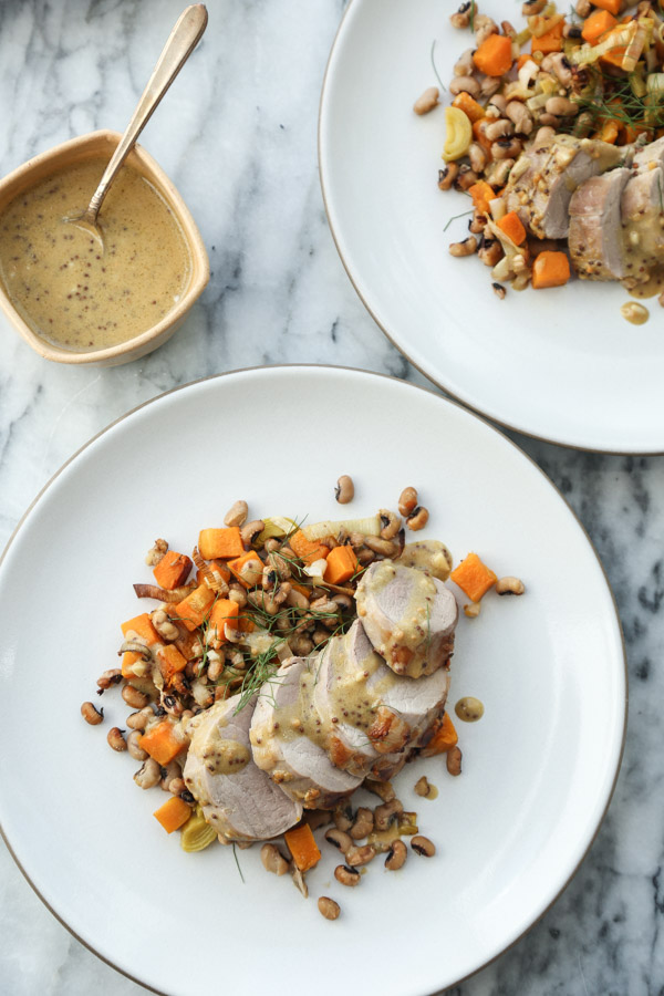 This easy roasted pork tenderloin recipe uses just a sheet pan! It's marinated in mustard sauce and baked in the oven with a healthy mix of butternut squash, black-eyed peas and leeks. | Gluten-Free | Feed Me Phoebe