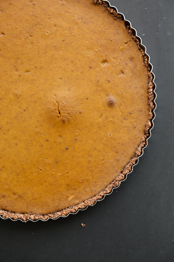 This gluten-free pumpkin tart is spiced with a hint of cayenne and clove. It's made with a Mexican chocolate almond crust. A great gluten-free Thanksgiving dessert recipe! | Feed Me Phoebe