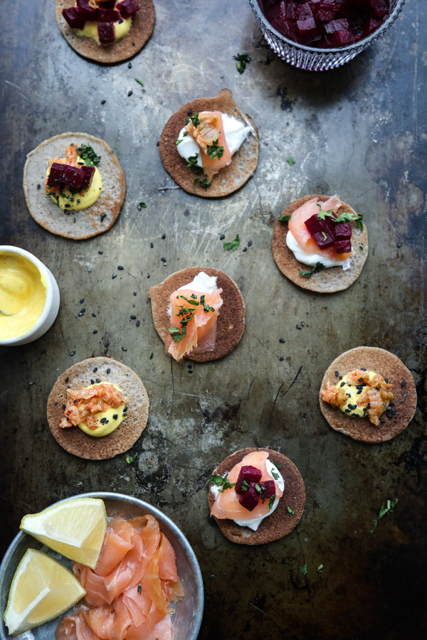 This buckwheat blini recipe is an easy, healthy spin on the traditional pancake, but tastes just as delicious! Serve to your gluten-free dairy-free friends! Top them with smoked salmon, beets, Greek yogurt and/or chopped kimchi