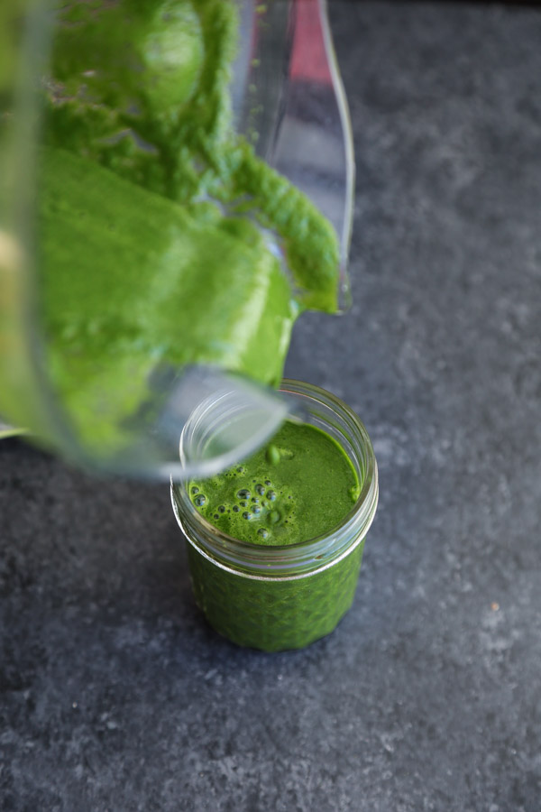 pouring green smoothie from blender