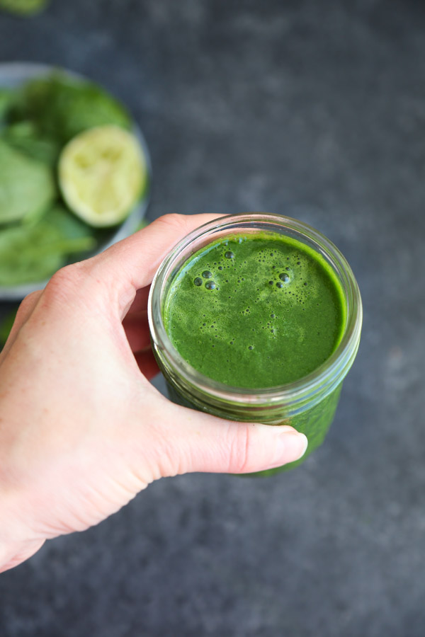 immune boosting green smoothie being held by hand