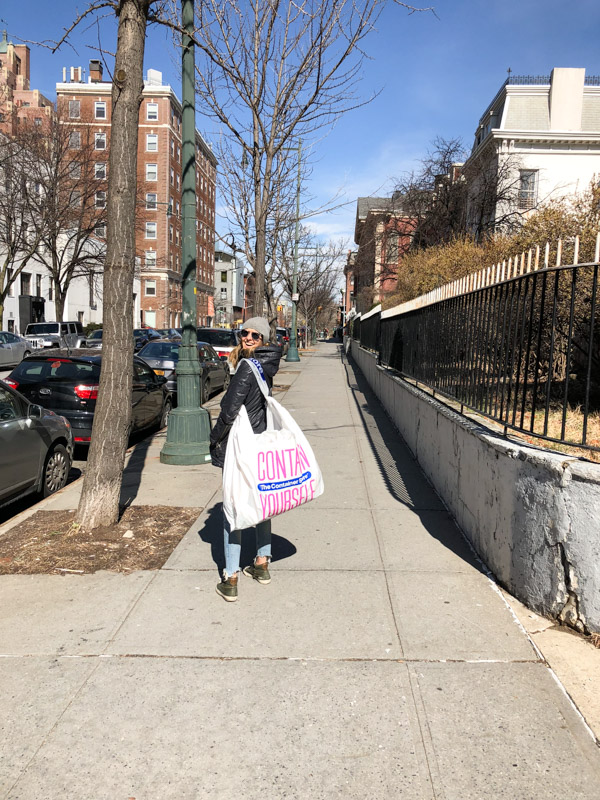 girl on a sidewalk with large plastic bag