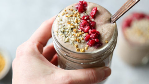raspberry smoothie with bee pollen and hibiscus in a glass with hand