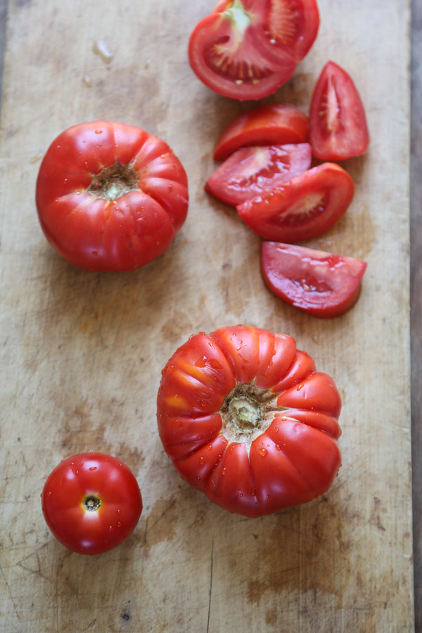 tomatoes on a brown wood cutting board