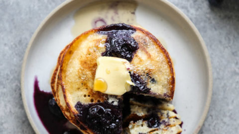stack of blueberry pancakes on a plate and fork