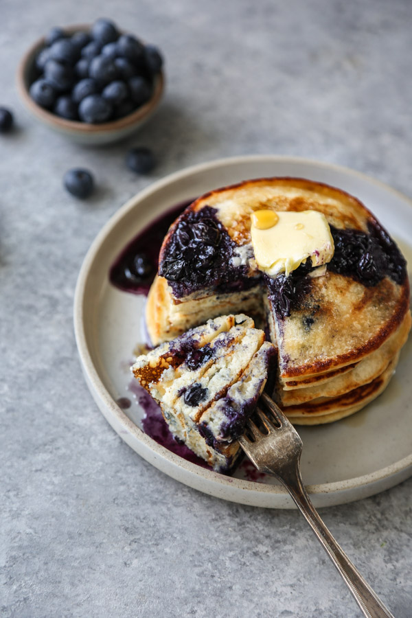 stack of blueberry pancakes on a plate with fork