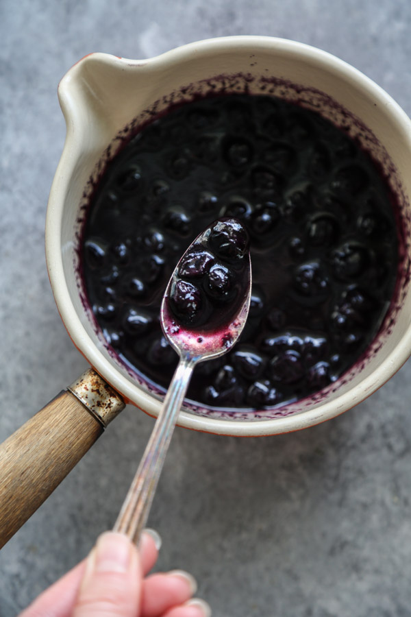 blueberry compote in a saucepan with a spoon