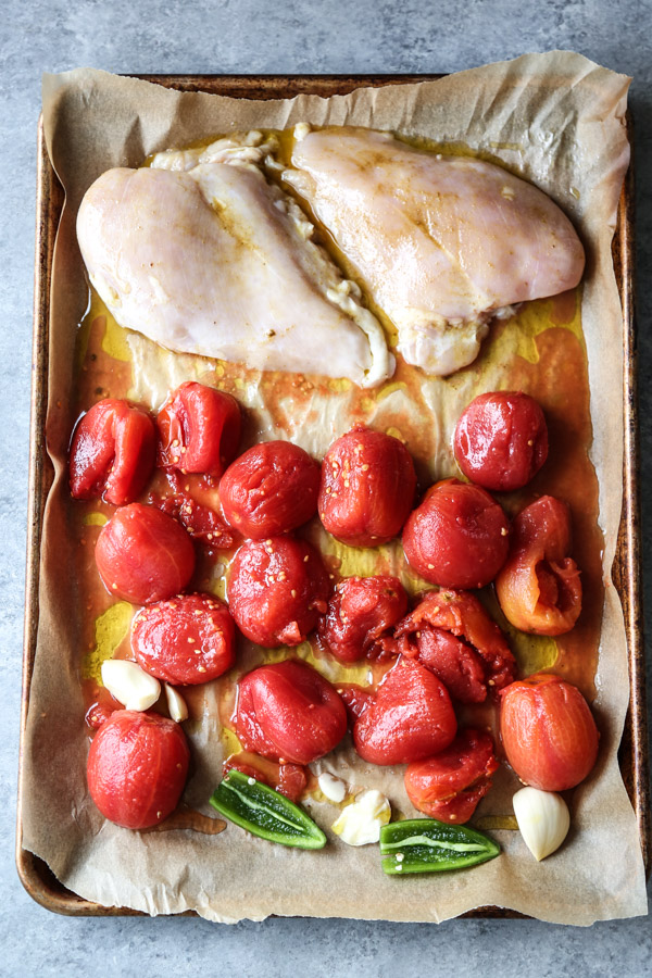 gluten-free chicken breasts on a sheet pan with tomatoes and jalapeno