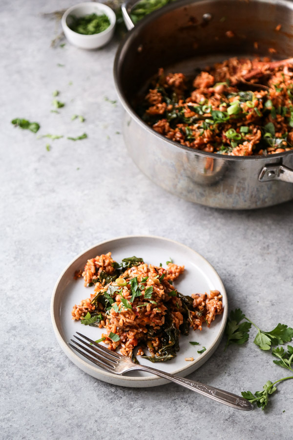 vegan jambalaya with greens in a pot and on a plate