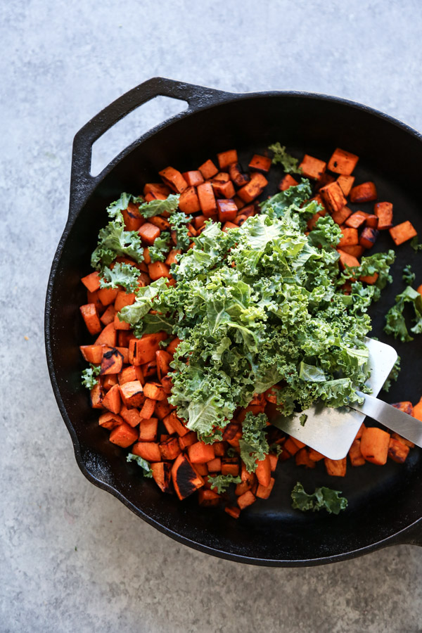 sweet potato hash with kale in a cast iron skillet