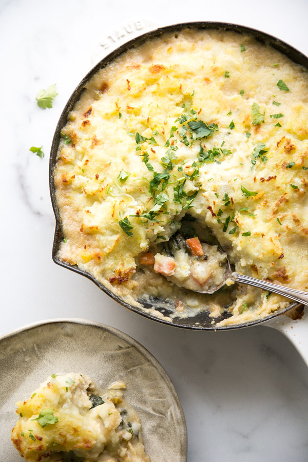 dairy-free fish pie in a skillet with spoonful taken out on a plate
