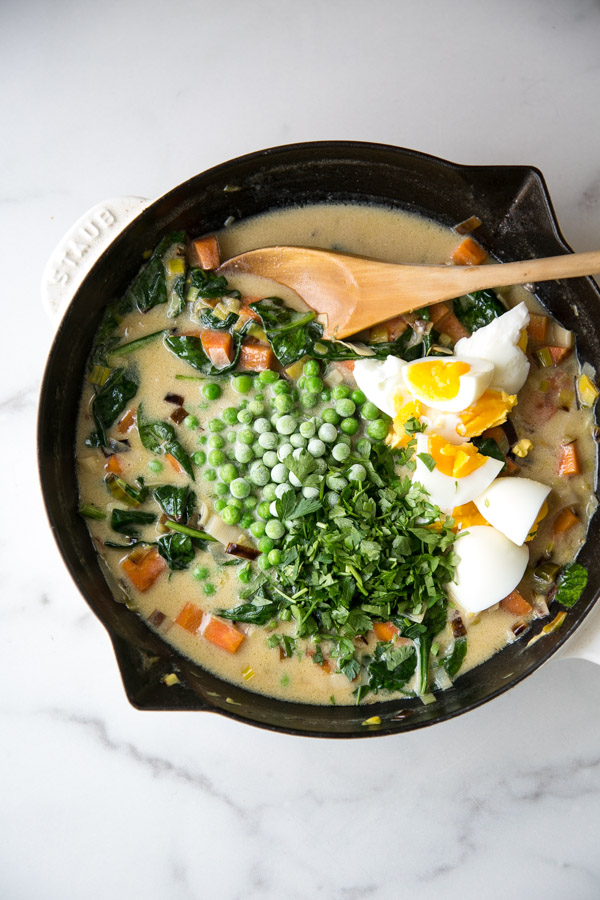 Hard boiled eggs, peas, spinach and other veggies in a dairy-free sauce