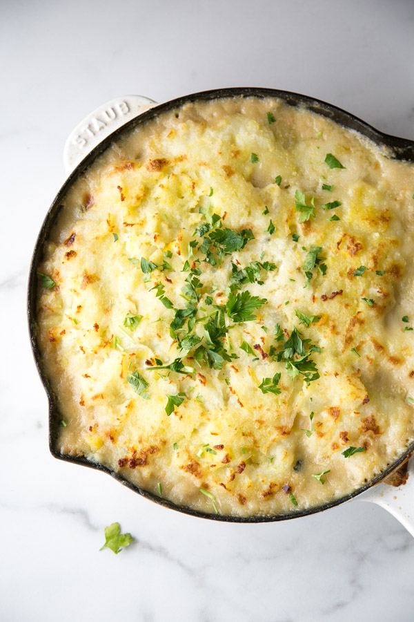 the finished gluten-free fish pie in a skillet garnished with parsley