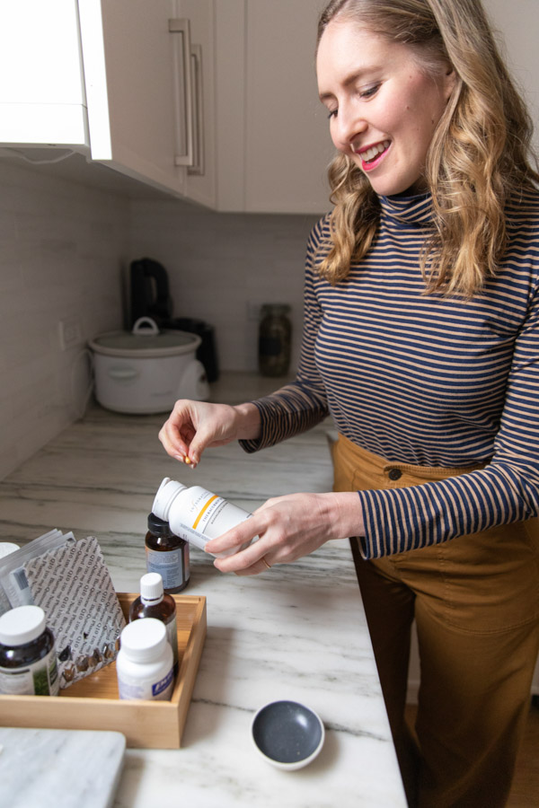 girl holding bottle for The best digestive enzymes supplements for IBS and SIBO