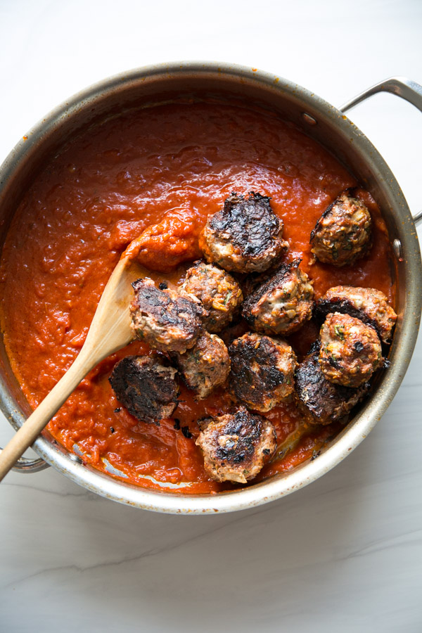 gluten-free meatballs in a pan with gluten-free pasta sauce