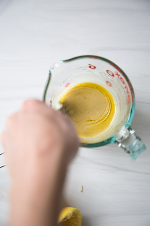 hand whisking oil into low fodmap dressing as it emulsifies