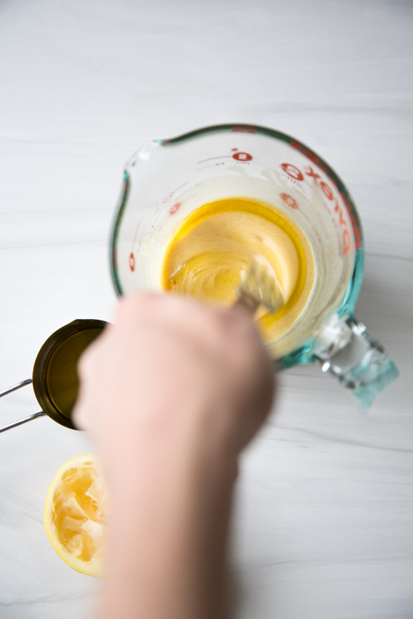 hand whisking oil into low fodmap dressing as it emulsifies faster