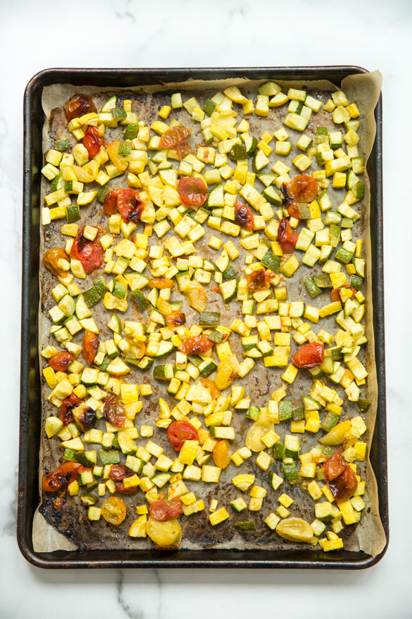 oven roasted zucchini squash and tomatoes on a sheet pan