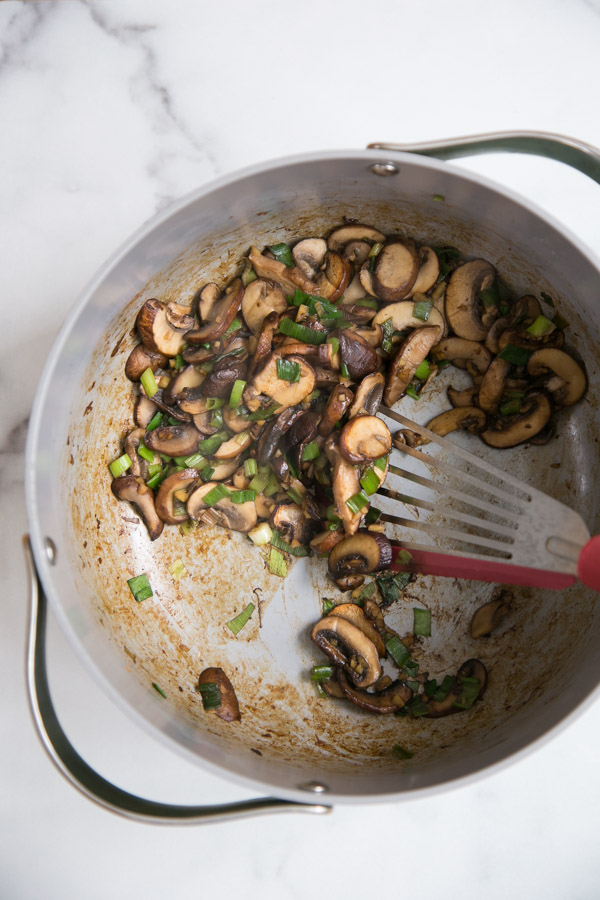 sauteed mushroom toppings for savory oatmeal in a pot with spatula