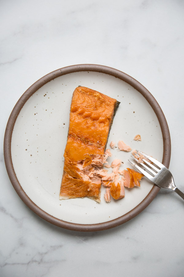 whole smoked salmon fillet on a plate with fork flaking it