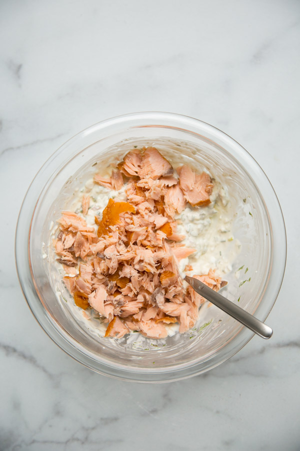 flaked smoked salmon in a mixing bowl with cream cheese dip