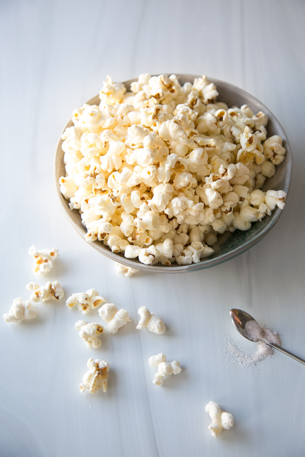 buttered low fodmap popcorn in a bowl with spoon of salt