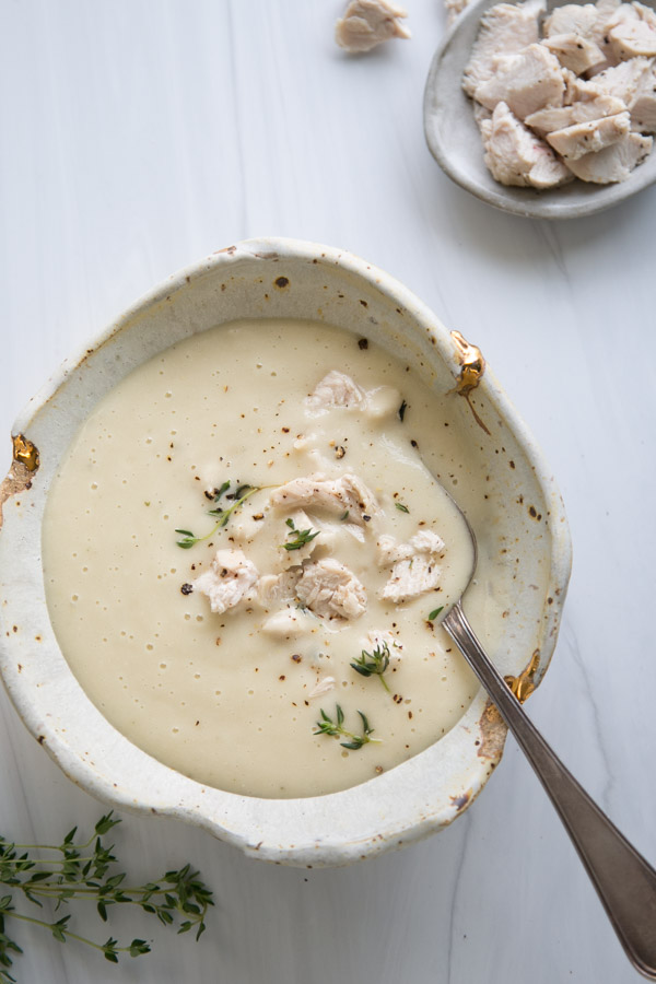 dairy-free cream of chicken soup in bowl with small bowl of chopped chicken