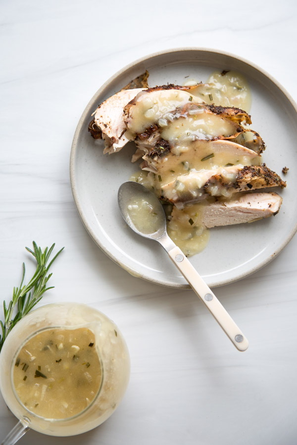 Plate of chicken covered in gluten-free gravy with more on the side
