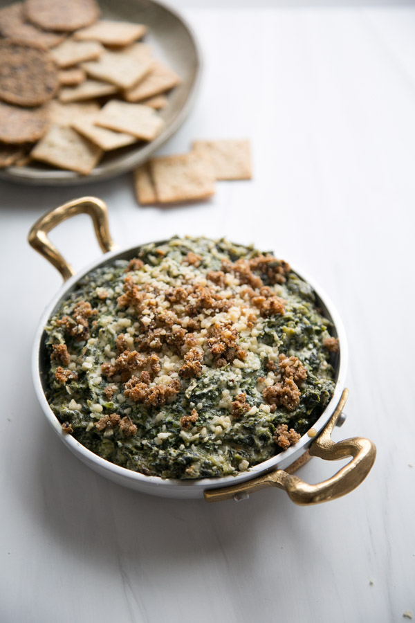 Roasted warm dairy-free spinach dipped in ramekins and topped with gluten-free bread crumbs