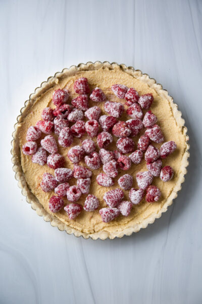 Add gluten-free raspberry and almond tarts to pan before baking