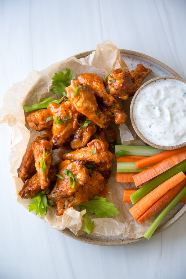 oven baked crispy gluten-free buffalo wings on a platter with dairy-free ranch