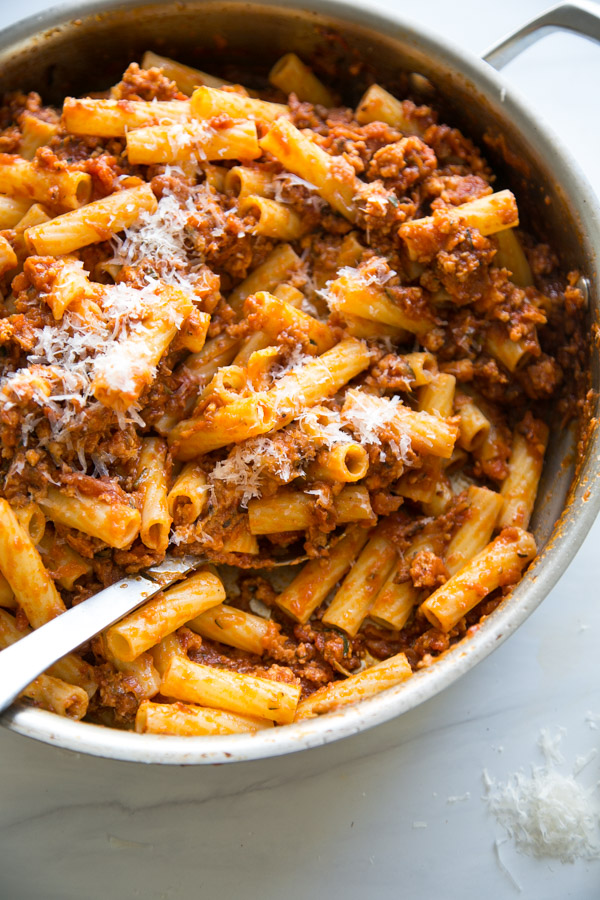 dairy-free bolognese sauce with low fodmap pasta in a saucepan with spoon