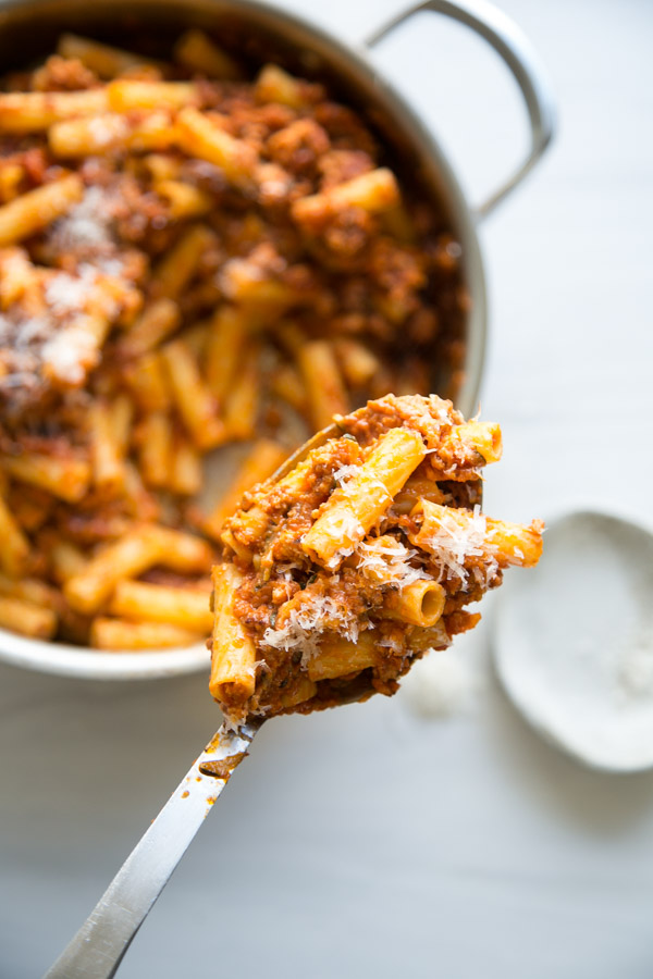 spoon holding portion of low FODMAP pasta bolognese with ground turkey sauce