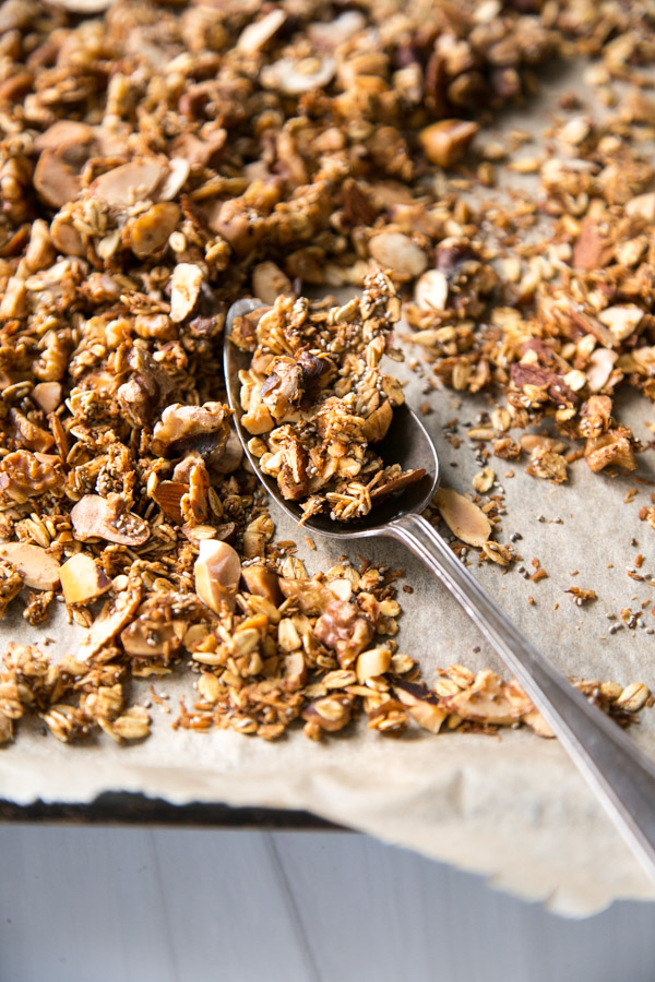 sugar-free granola on a sheet pan with a spoon close up