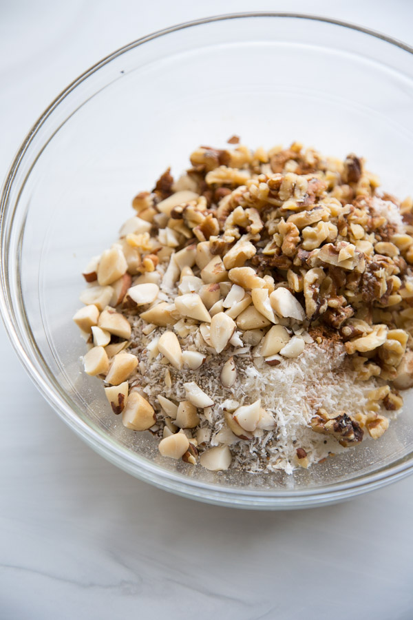 mixing bowl with walnuts, dried coconut, almonds and brazil nuts for sugar-free granola